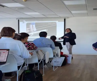 Participants in a classroom while a trainer presents a device