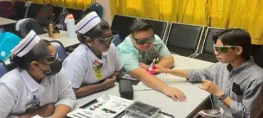 Nurses and a trainer practicing a procedure at a table